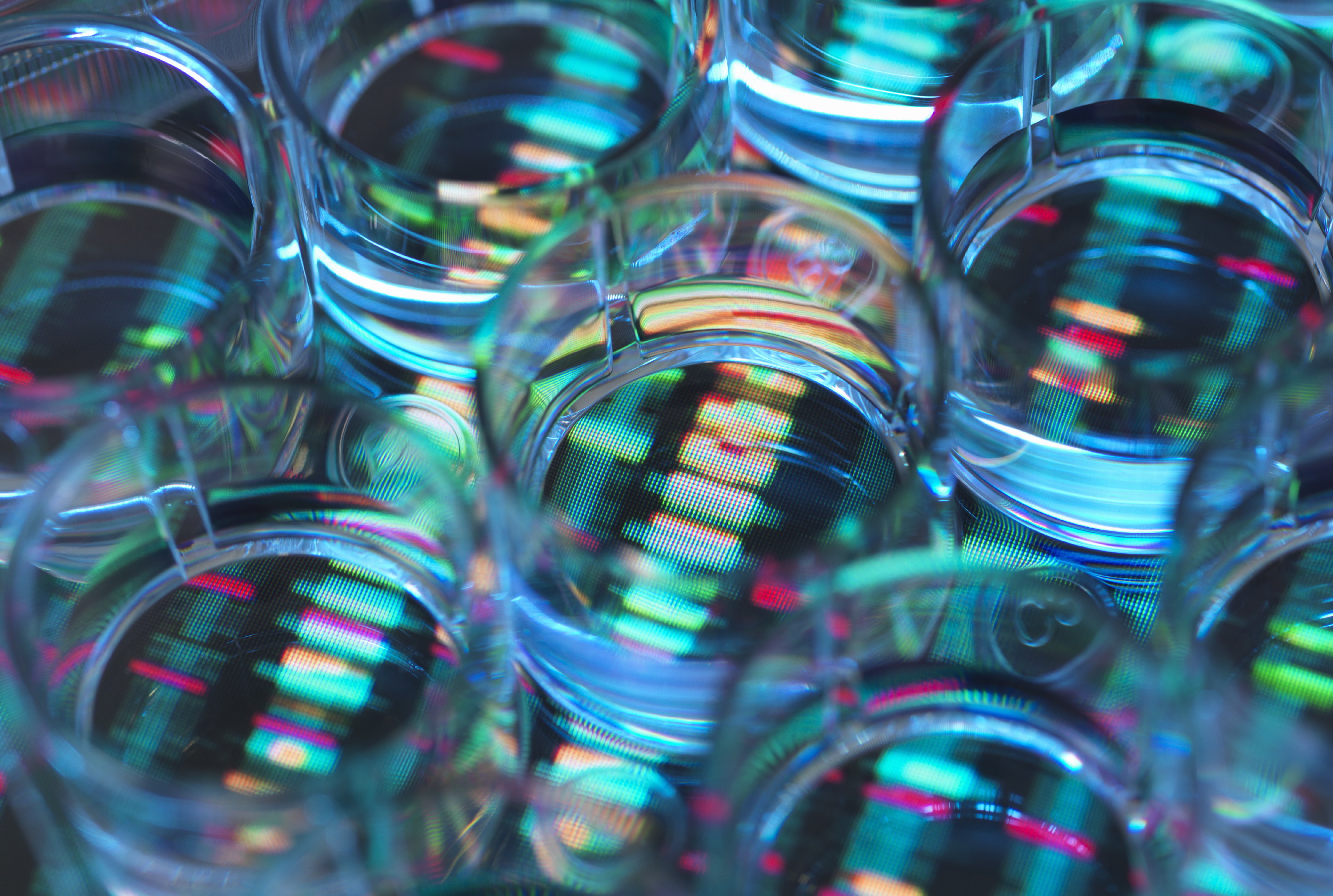 A human sample in a multi well plate ready for genetic analysis with a DNA sequence in the background