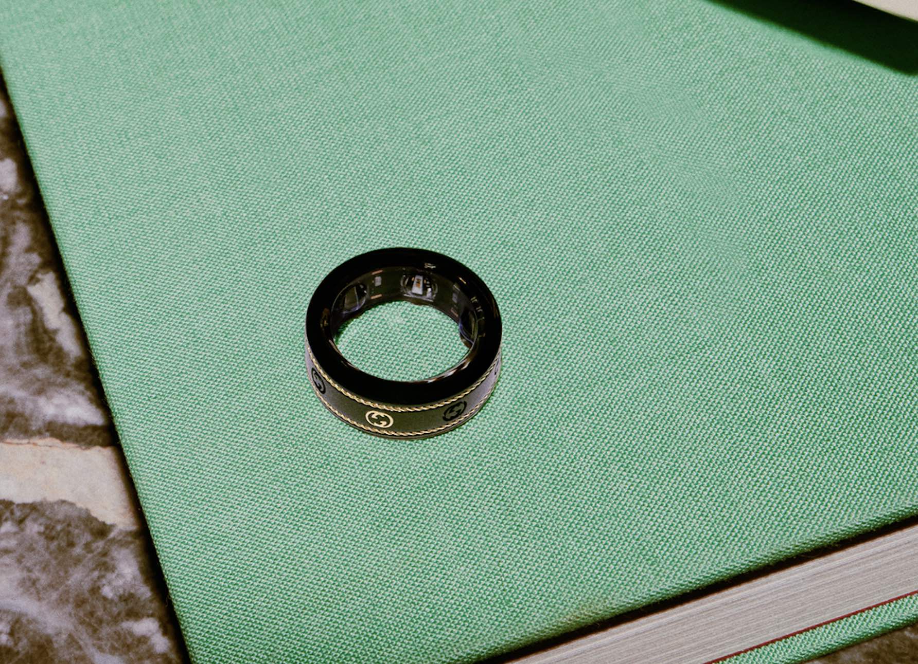 Black Gucci x Oura ring on green book