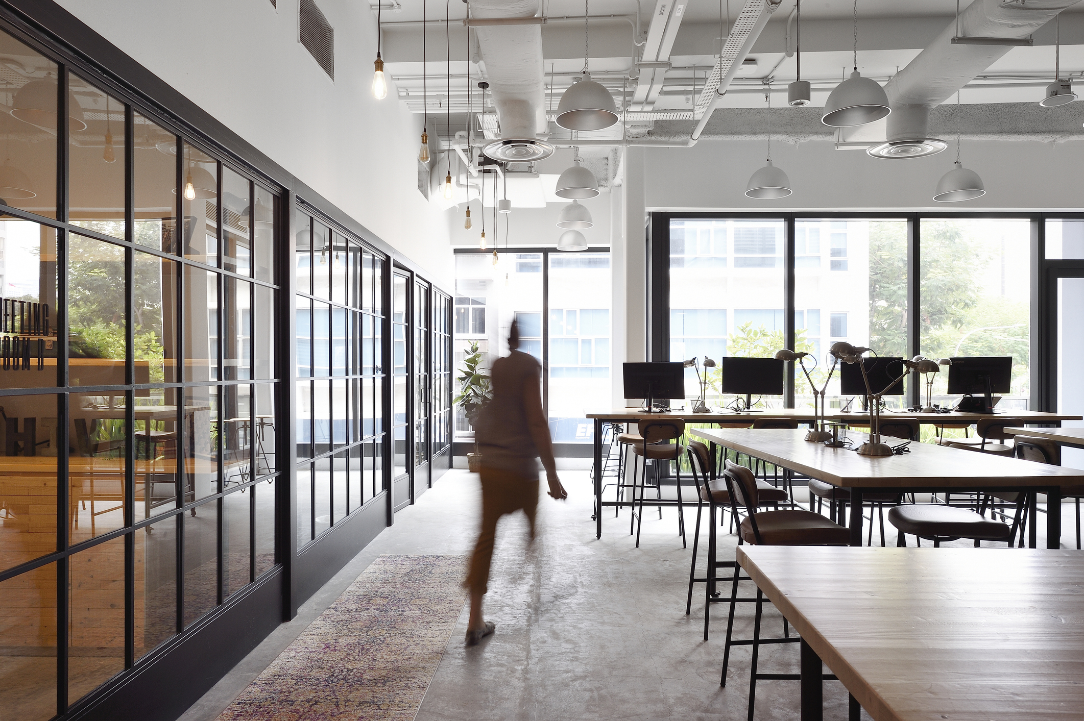 Woman walking through a co-working office, used in a post about Glints hiring report