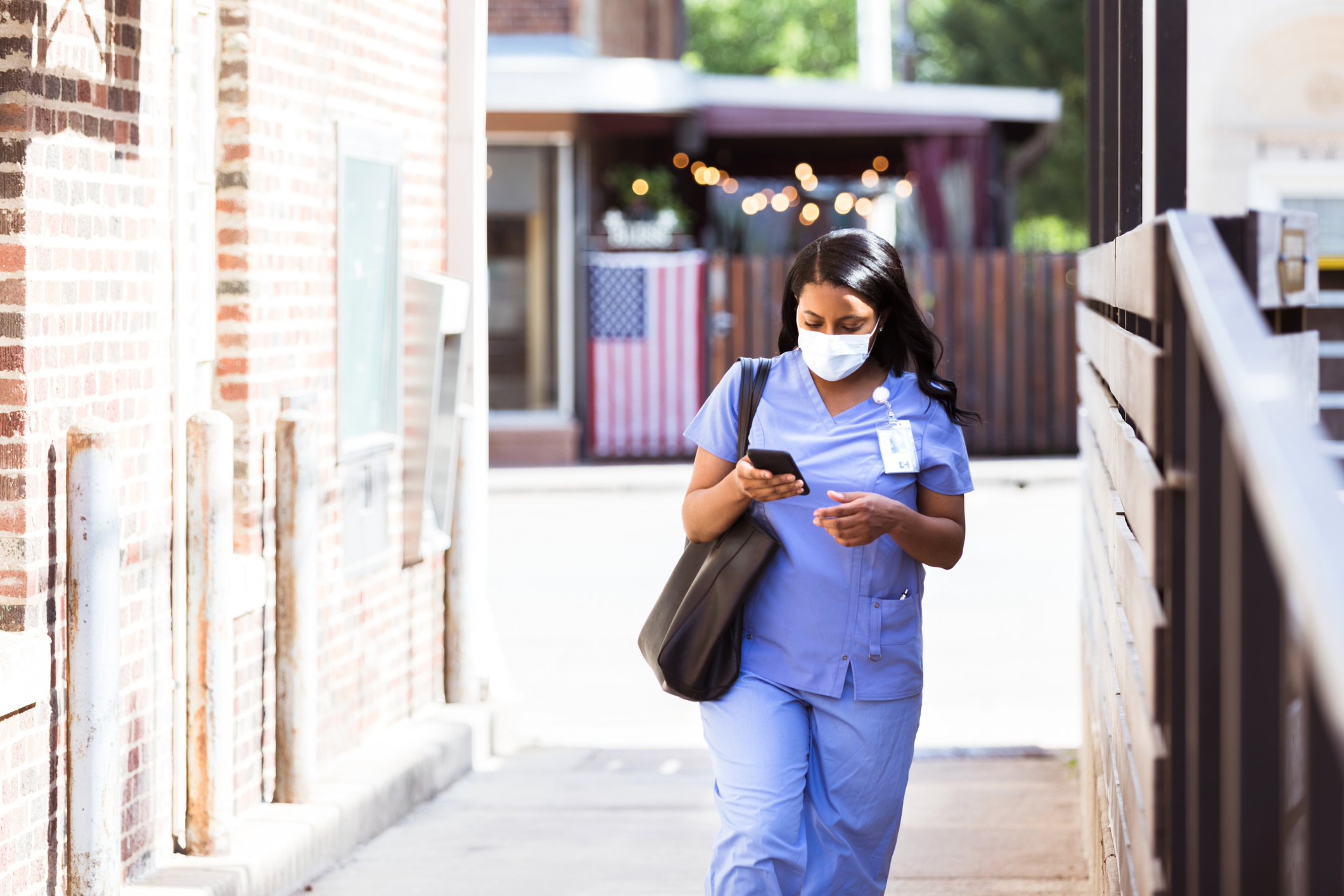 Nurse wearing a protective face mask walks to work. Used in post about Tebra, an operating system for independent healthcare providers