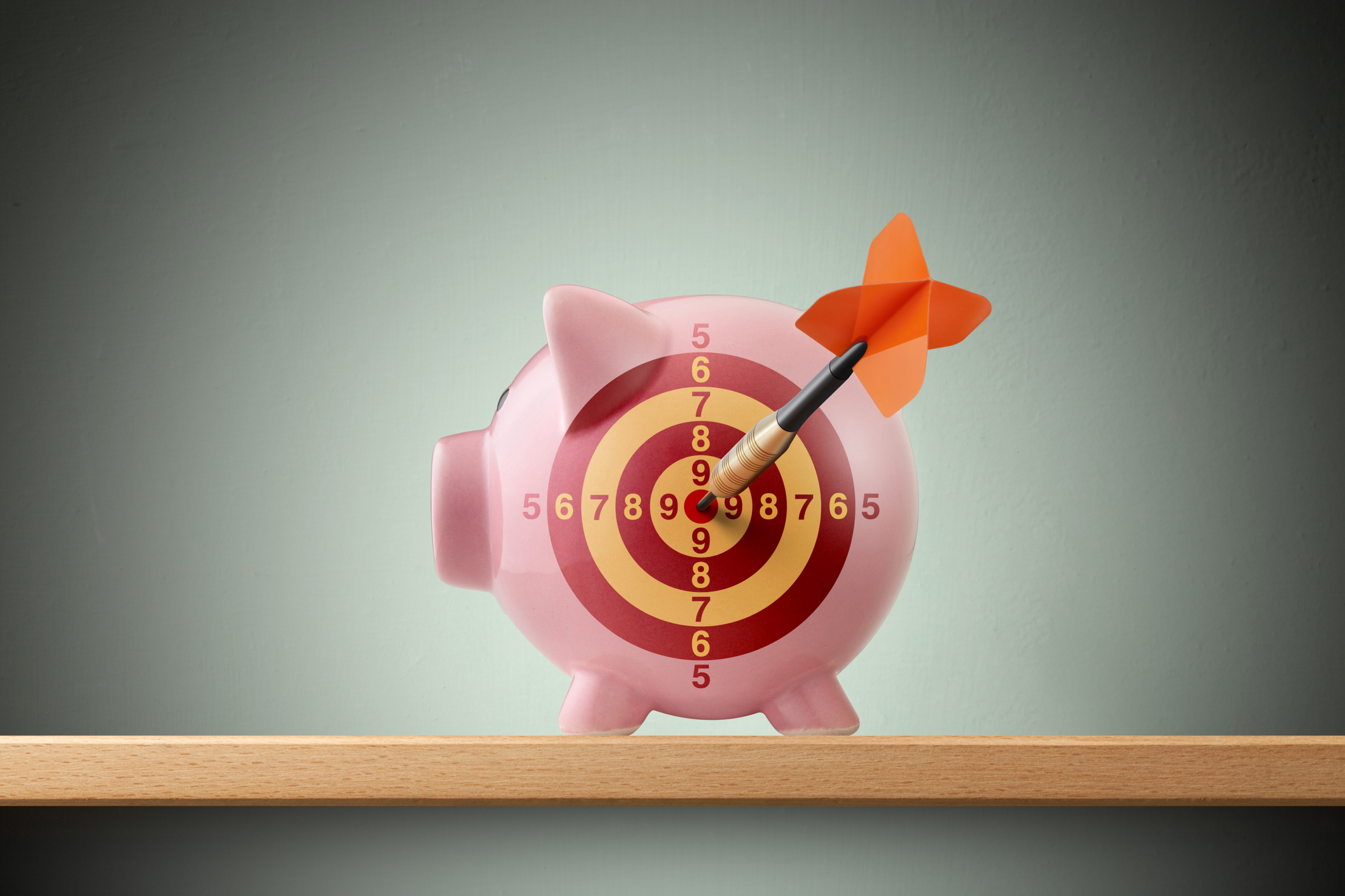 Piggy bank with dart in bull's eye on shelf. become undeniably fundable startups pivot funding