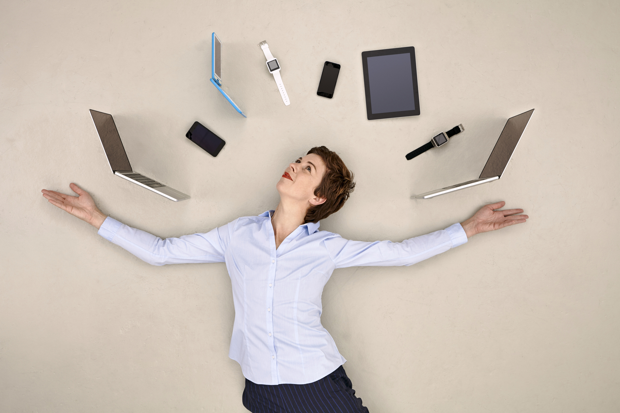 Woman juggling smartphones, tablets and smart watches, used in a post about Respond.io