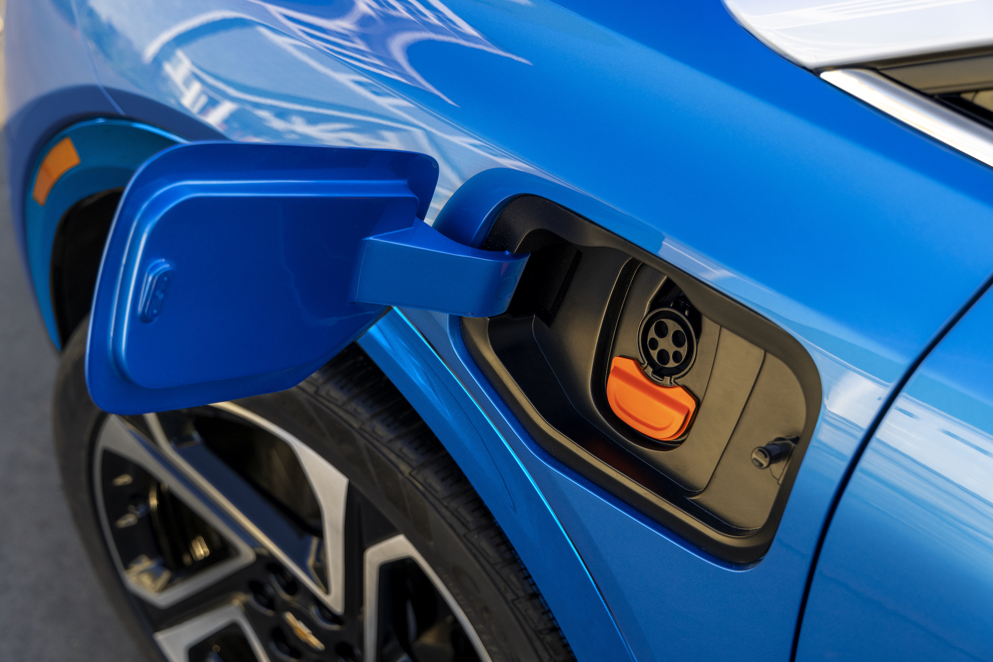 A closeup of the charging port on a Blue Chevrolet Equinox