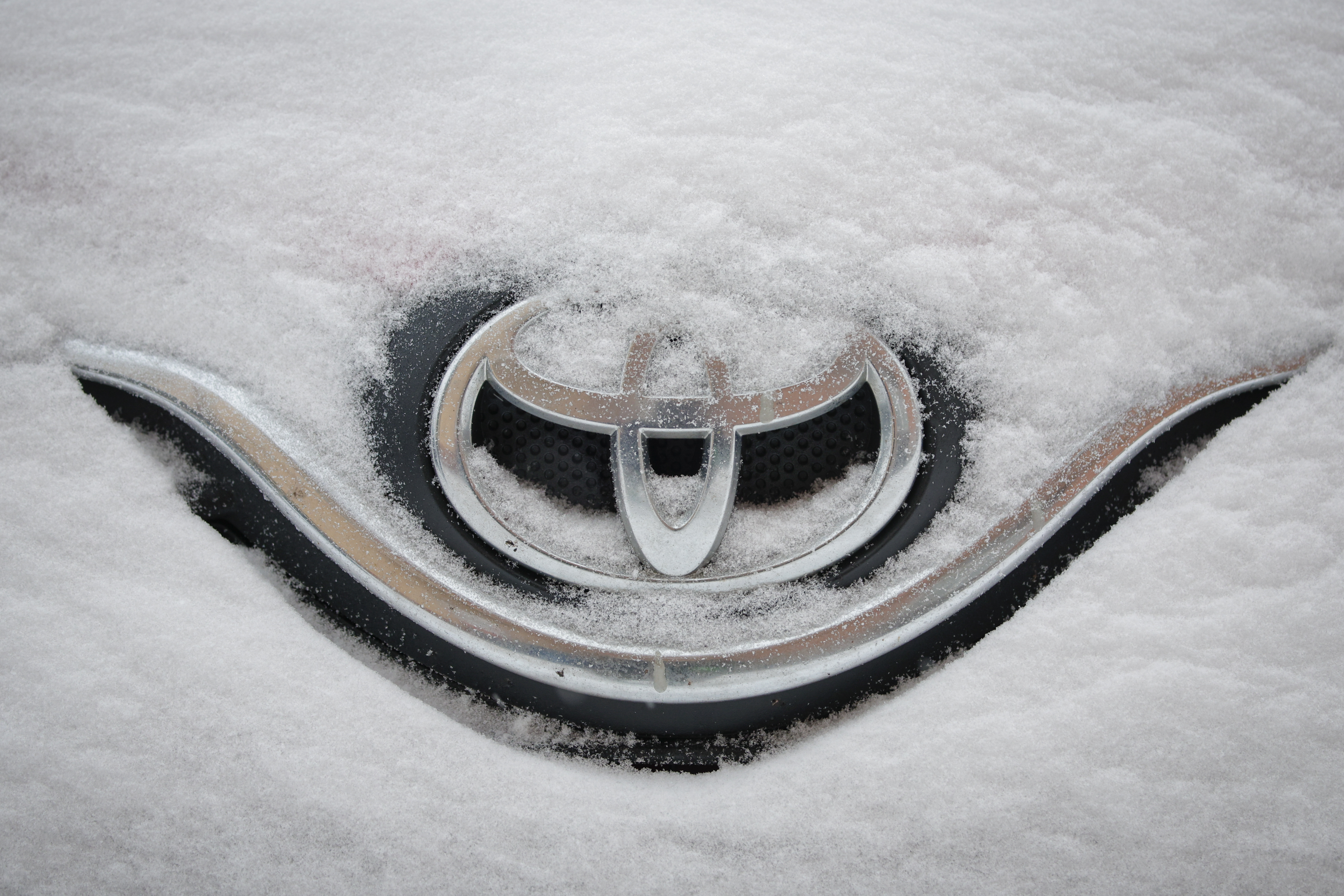 Toyota badge buried under snow.