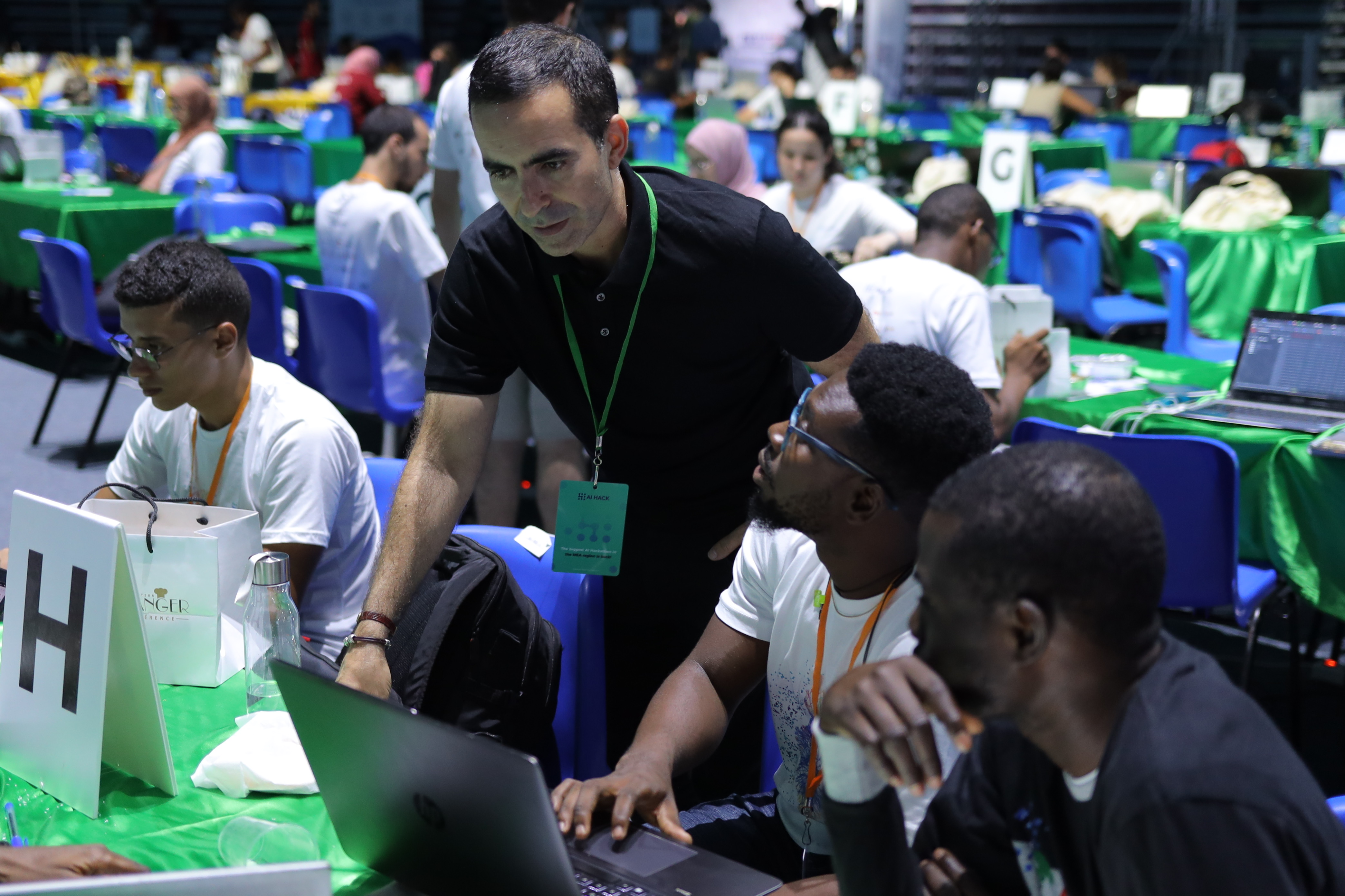 man standing over a table of people coding