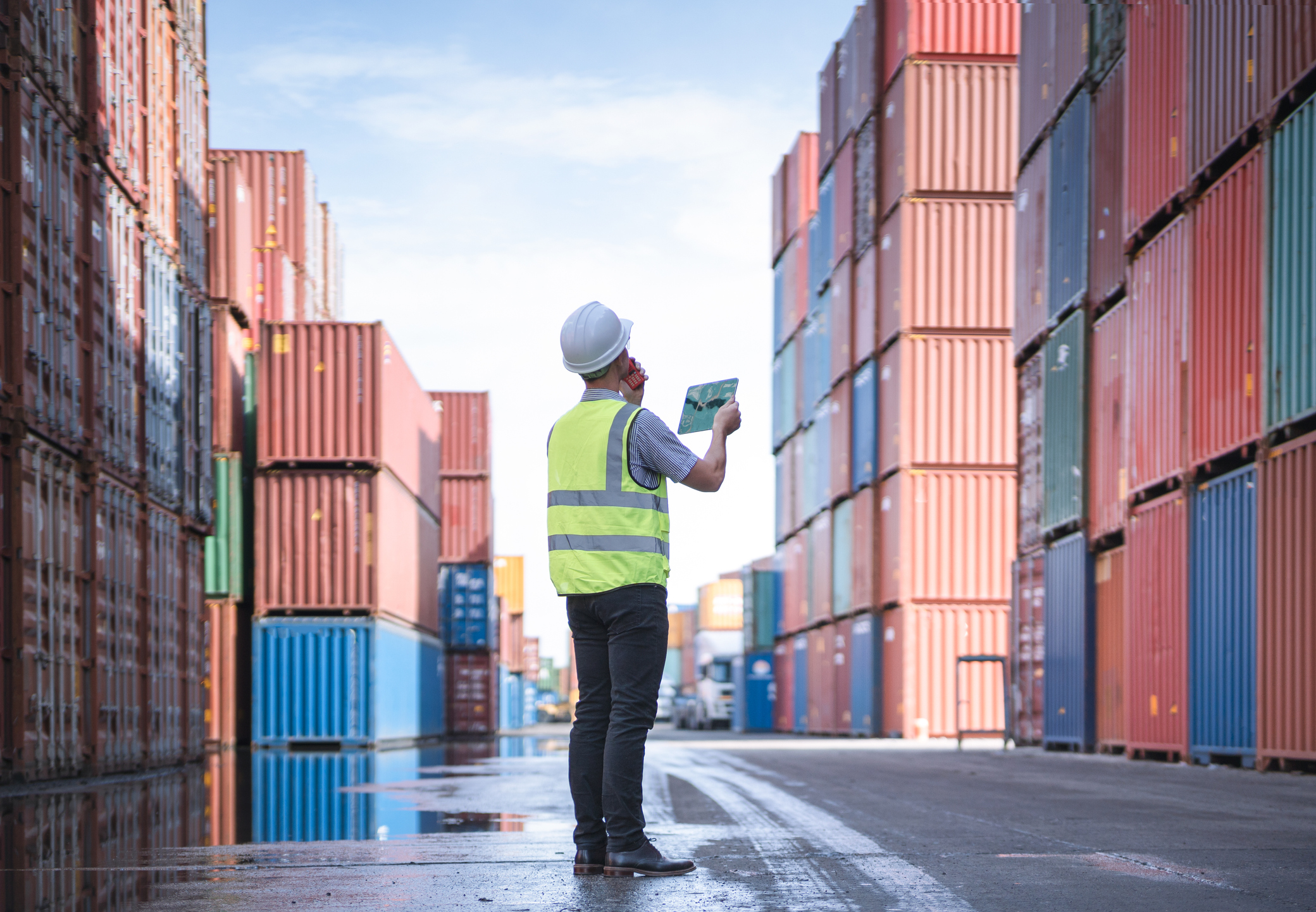 Engineer with tablet at Containers yard from Cargo freight ship for import export, used in a post about Freightify