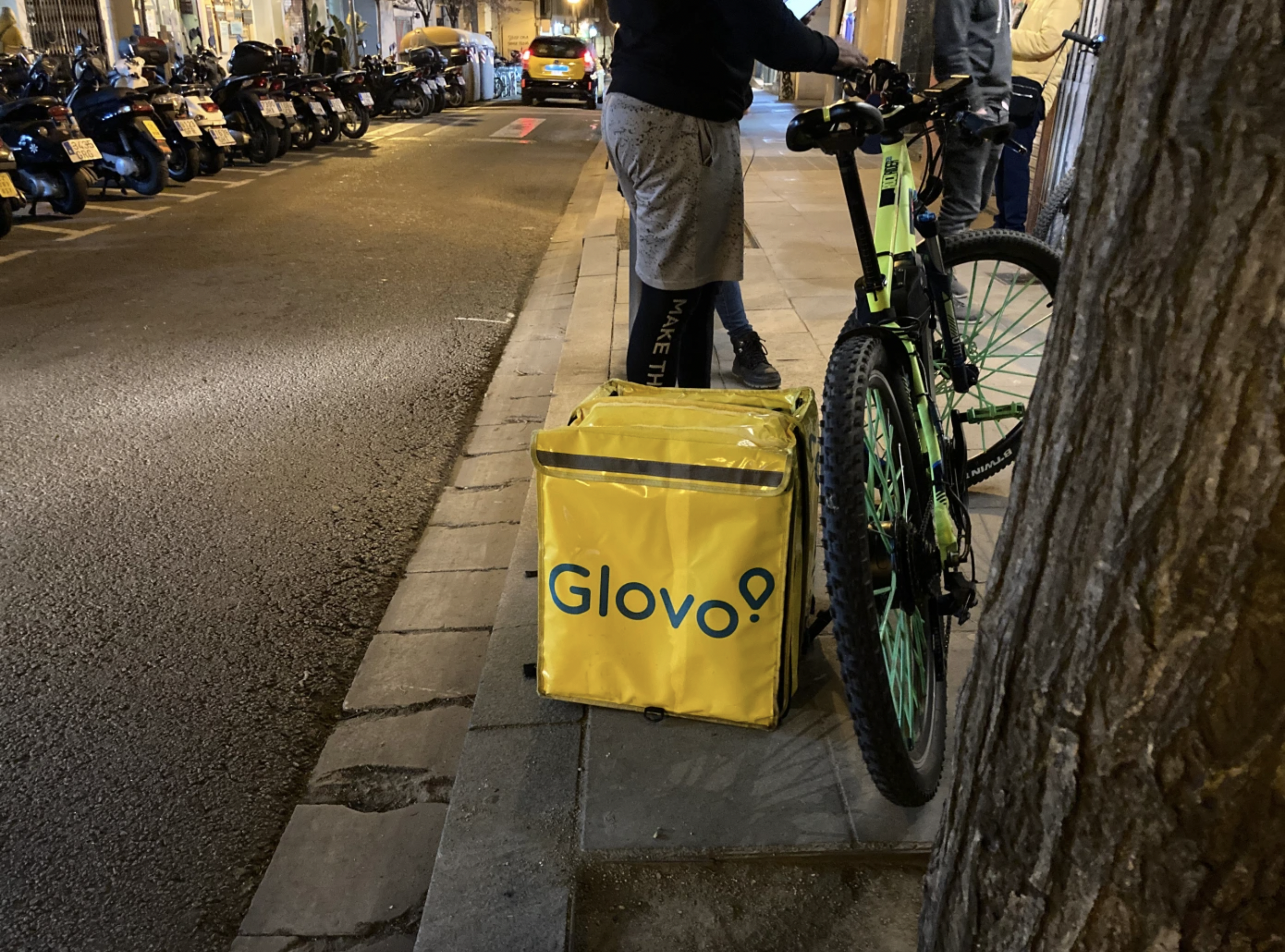 Glovo rider standing next to a bike