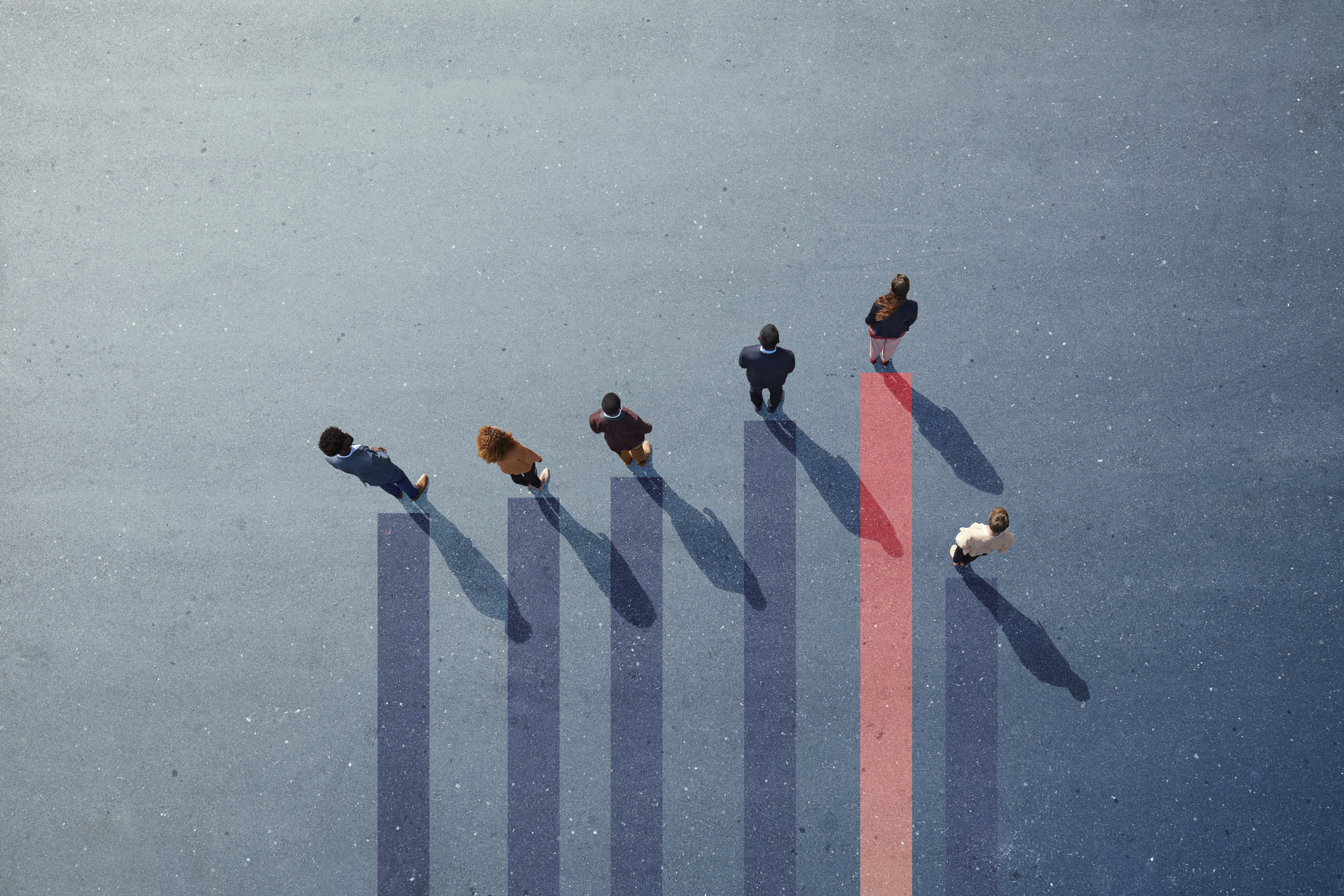 Group of employees photographed from above standing on graph.