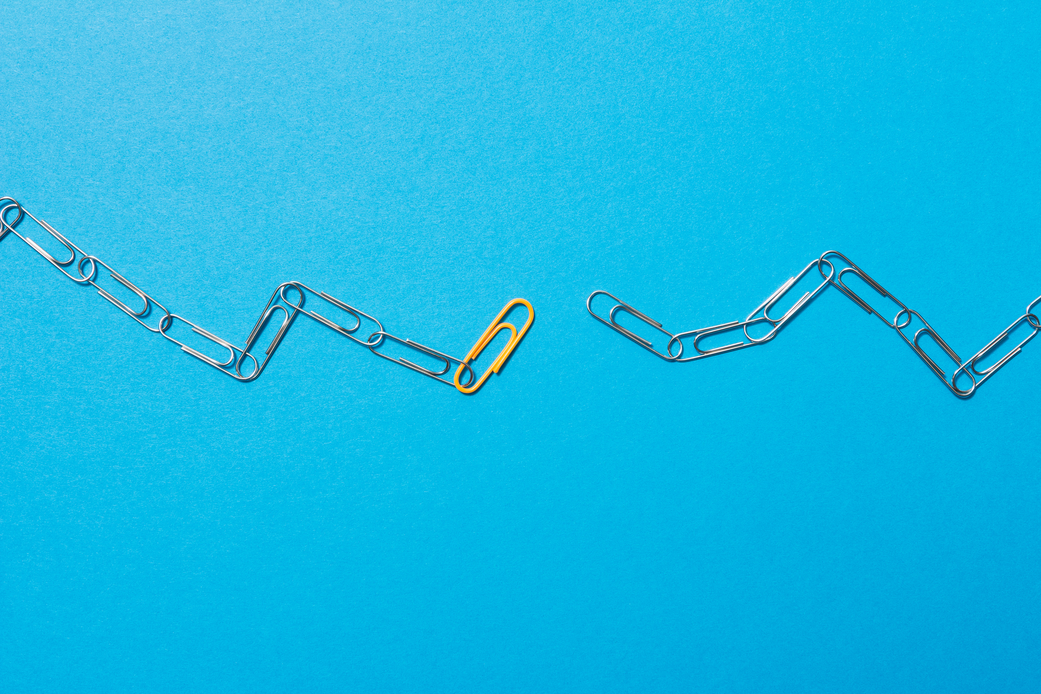 Chains formed by paperclips in which an orange clip serves as a link.