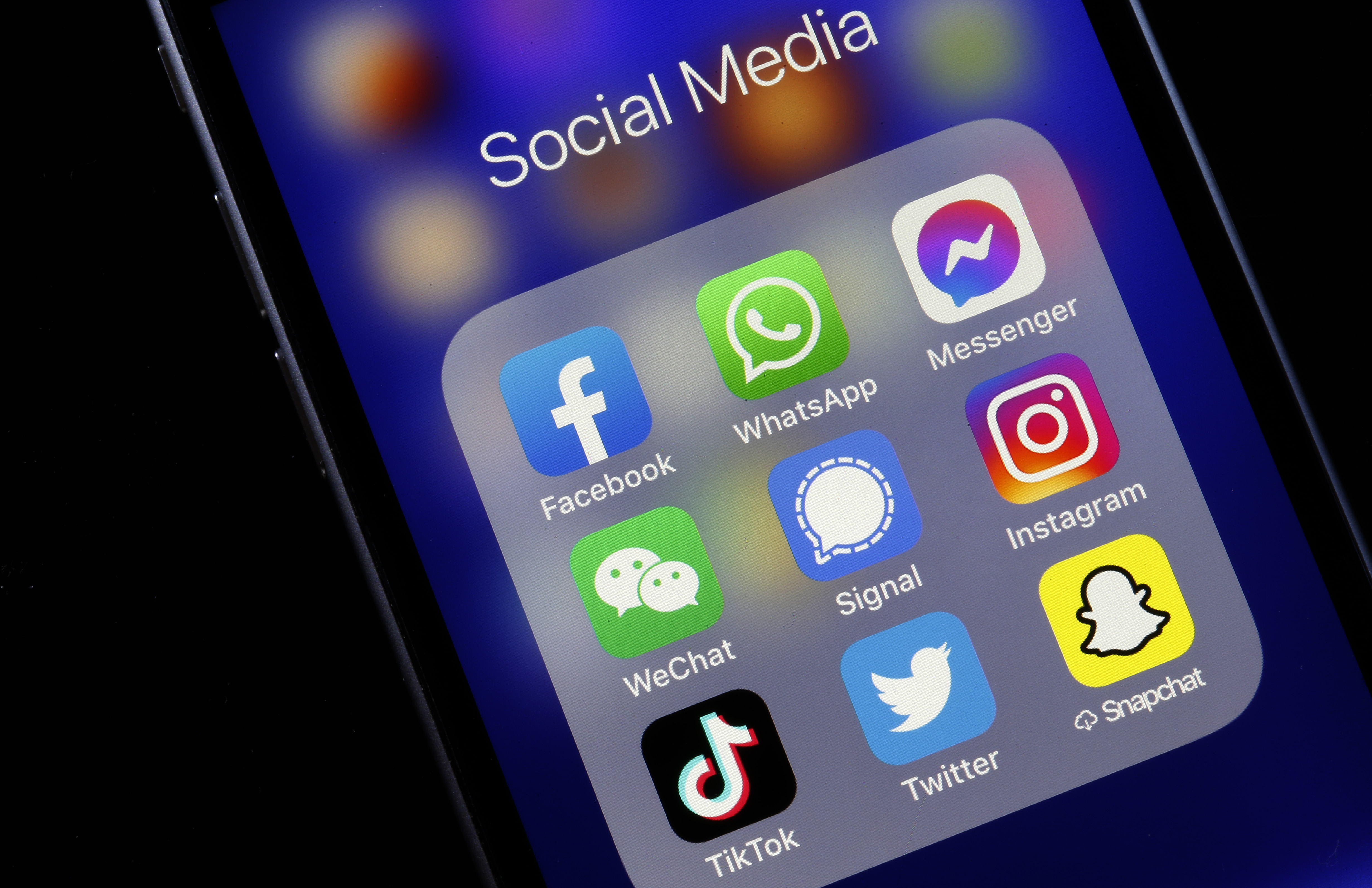 An iphone showing the most popular social apps in a folder.