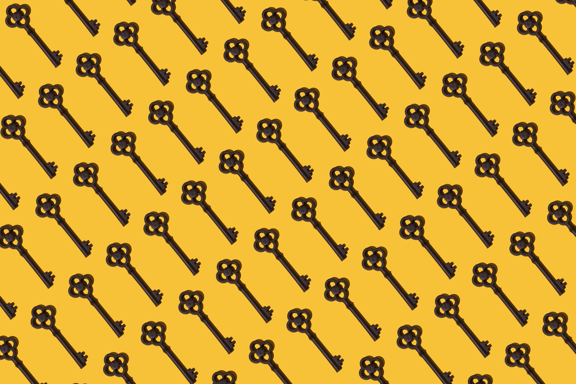 a pattern of antique keys on a yellow mustard background