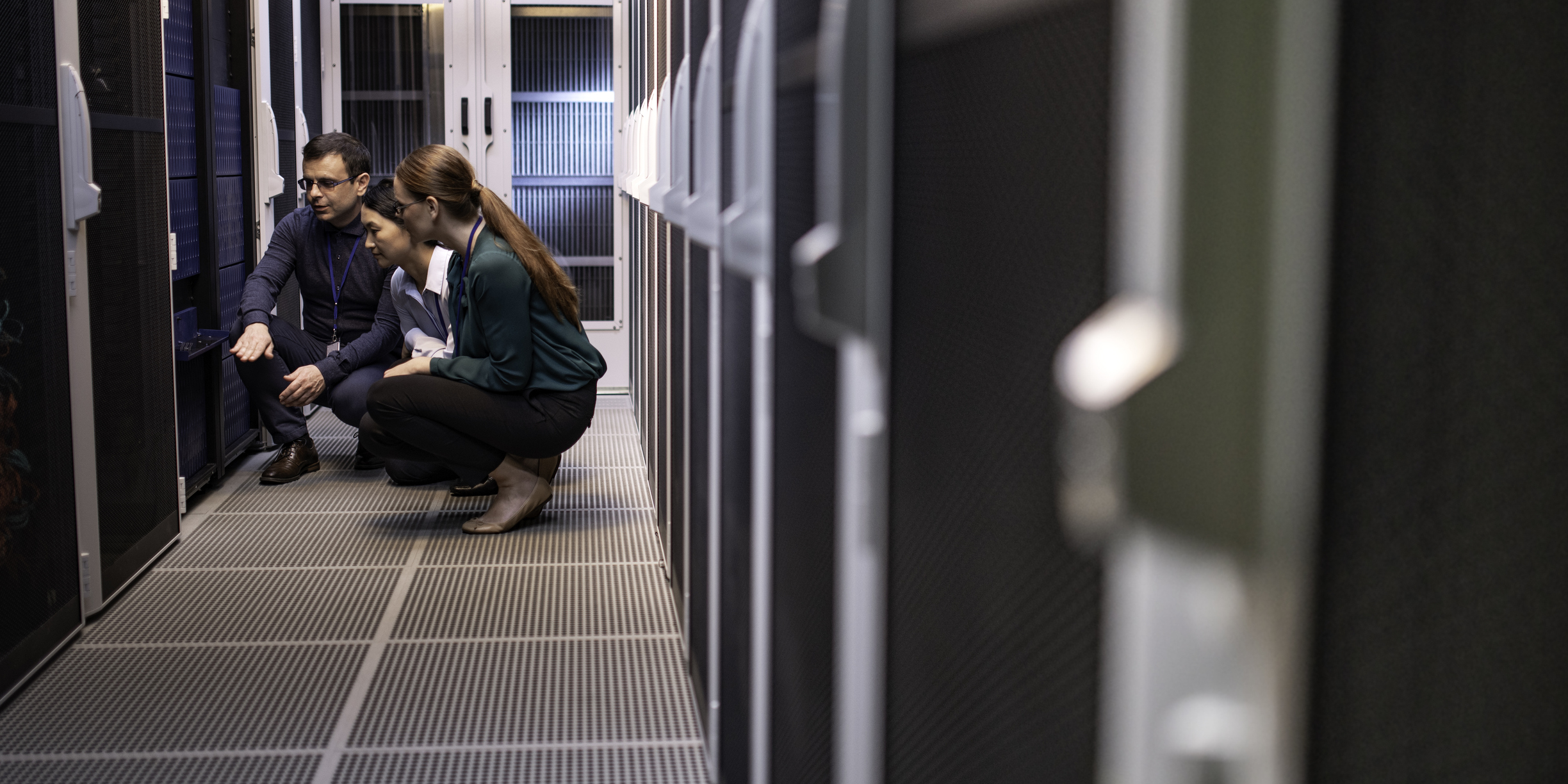 Team of engineers in a server room trying to diagnose a problem.