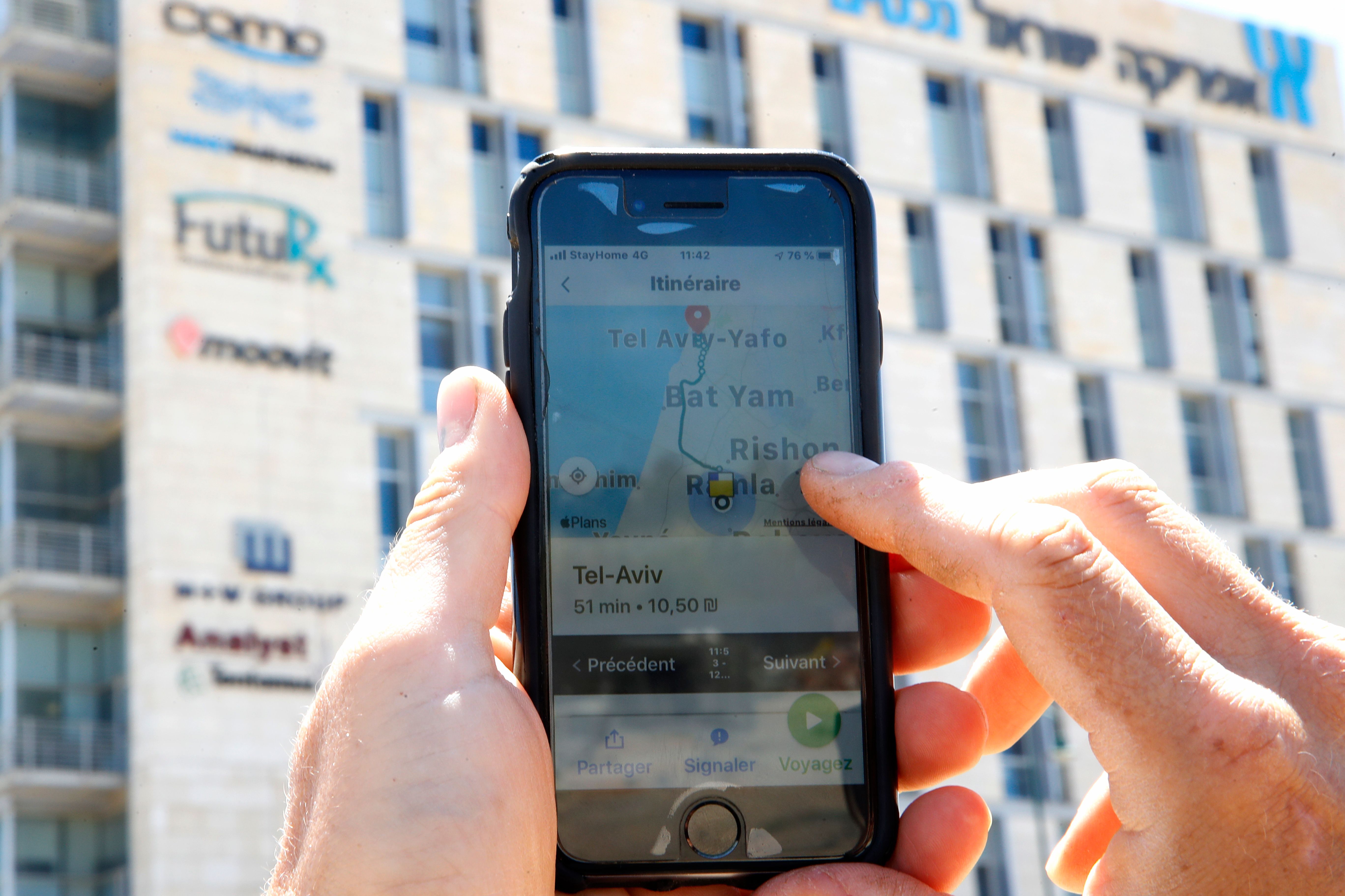 A man checks on his phone the Moovit mobile transport application in the central Israeli city of Ness Ziona on May 4, 2020. (Photo by JACK GUEZ / AFP) (Photo by JACK GUEZ/AFP via Getty Images)
