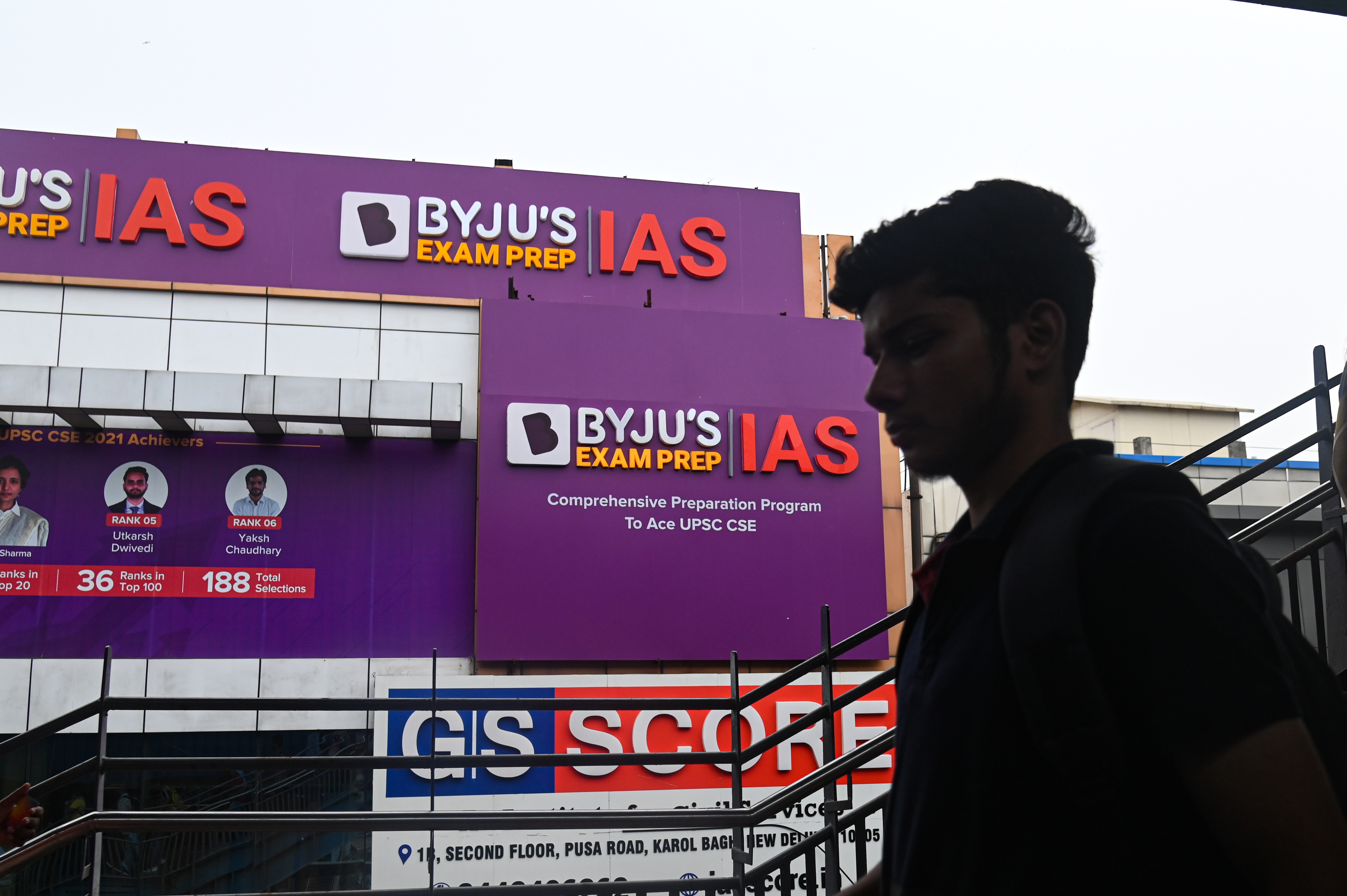 A boy walks past an hoarding of Byju's IAS coaching center in New Delhi, India on June 24, 2023. Byju's, an Education Technology company, and one of the top India's Startup, is in crisis since it has missed its interest payment on its $1.2 billion loan and other various issues. (Photo by Kabir Jhangiani/NurPhoto via Getty Images)