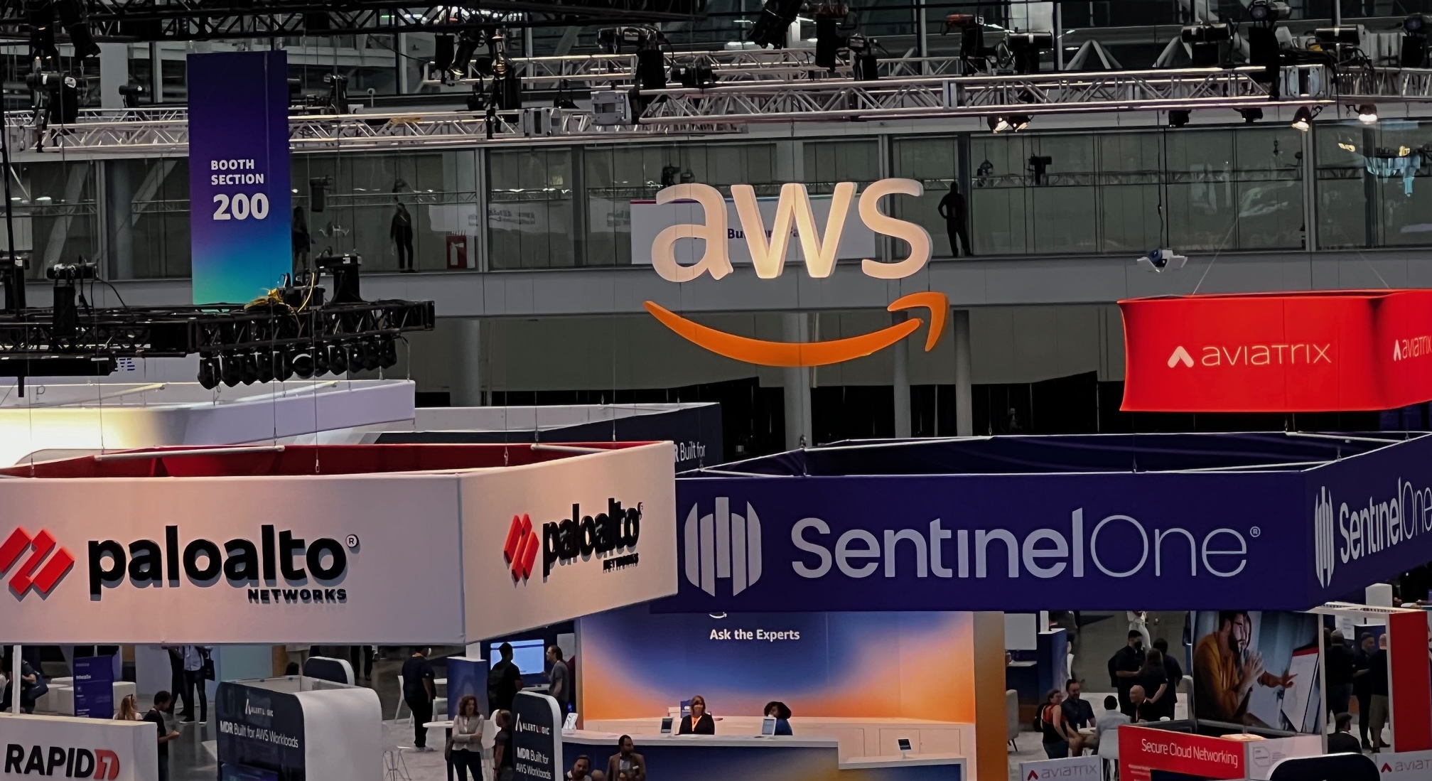 Conference floor with booths from companies like AWS, Palo Alto Networks, Rapid 7 and others taken from above.