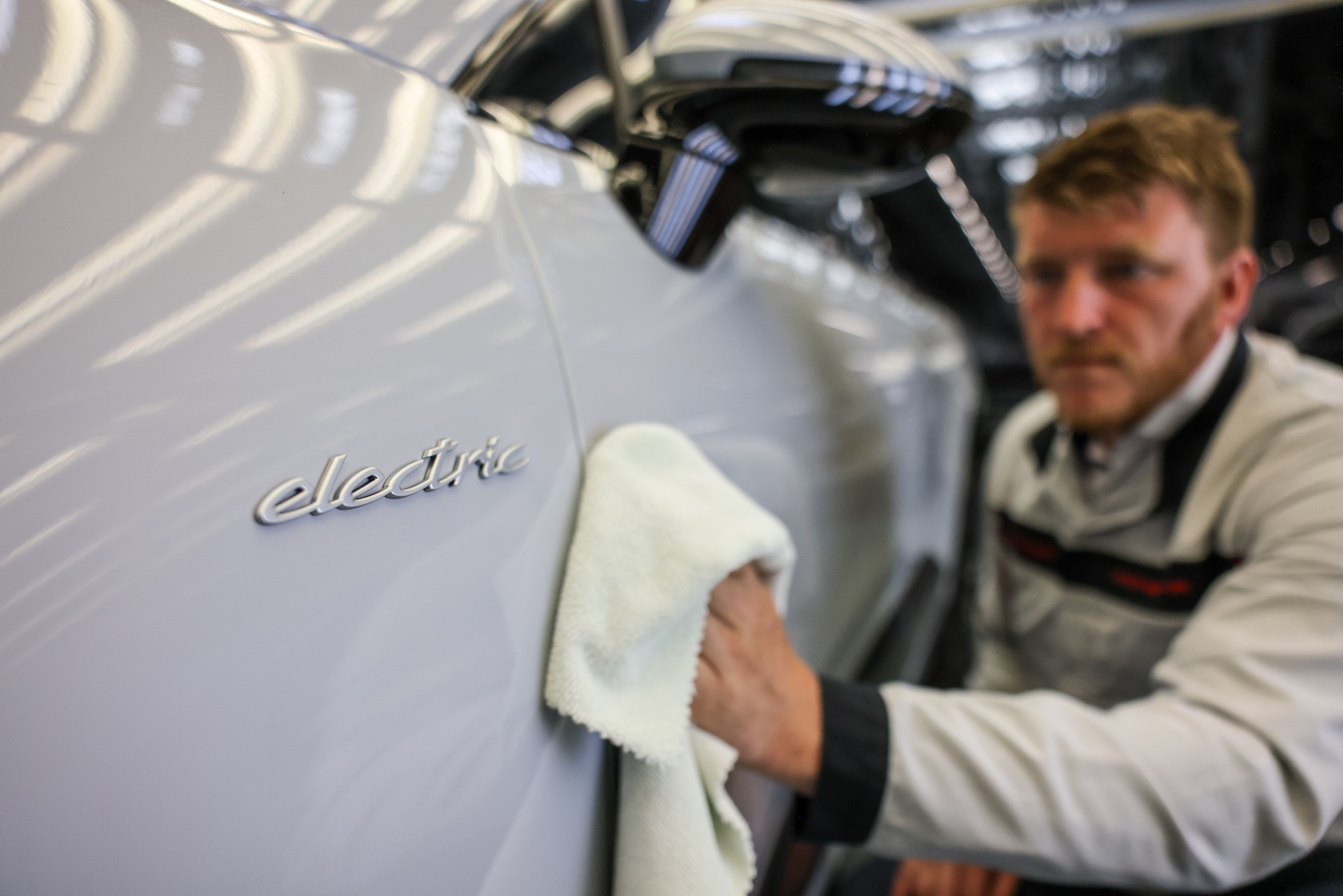 A Porsche employee checks an all-electric Porsche Macan in quality control at the Leipzig plant.