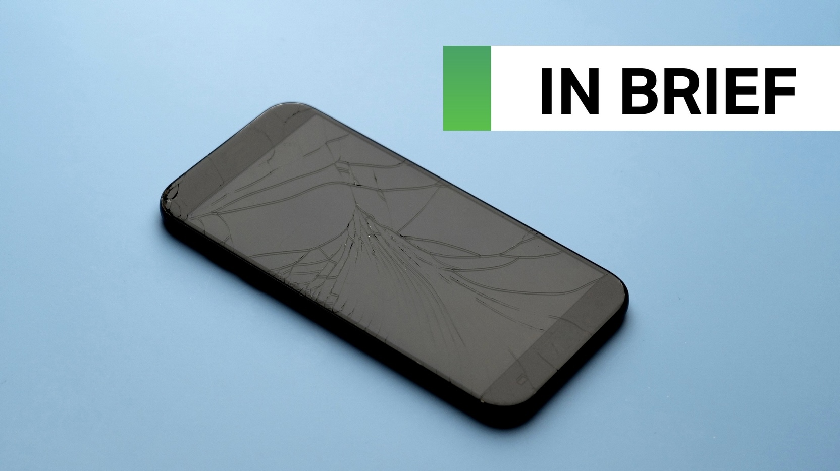 A broken phone on a blue table background.
