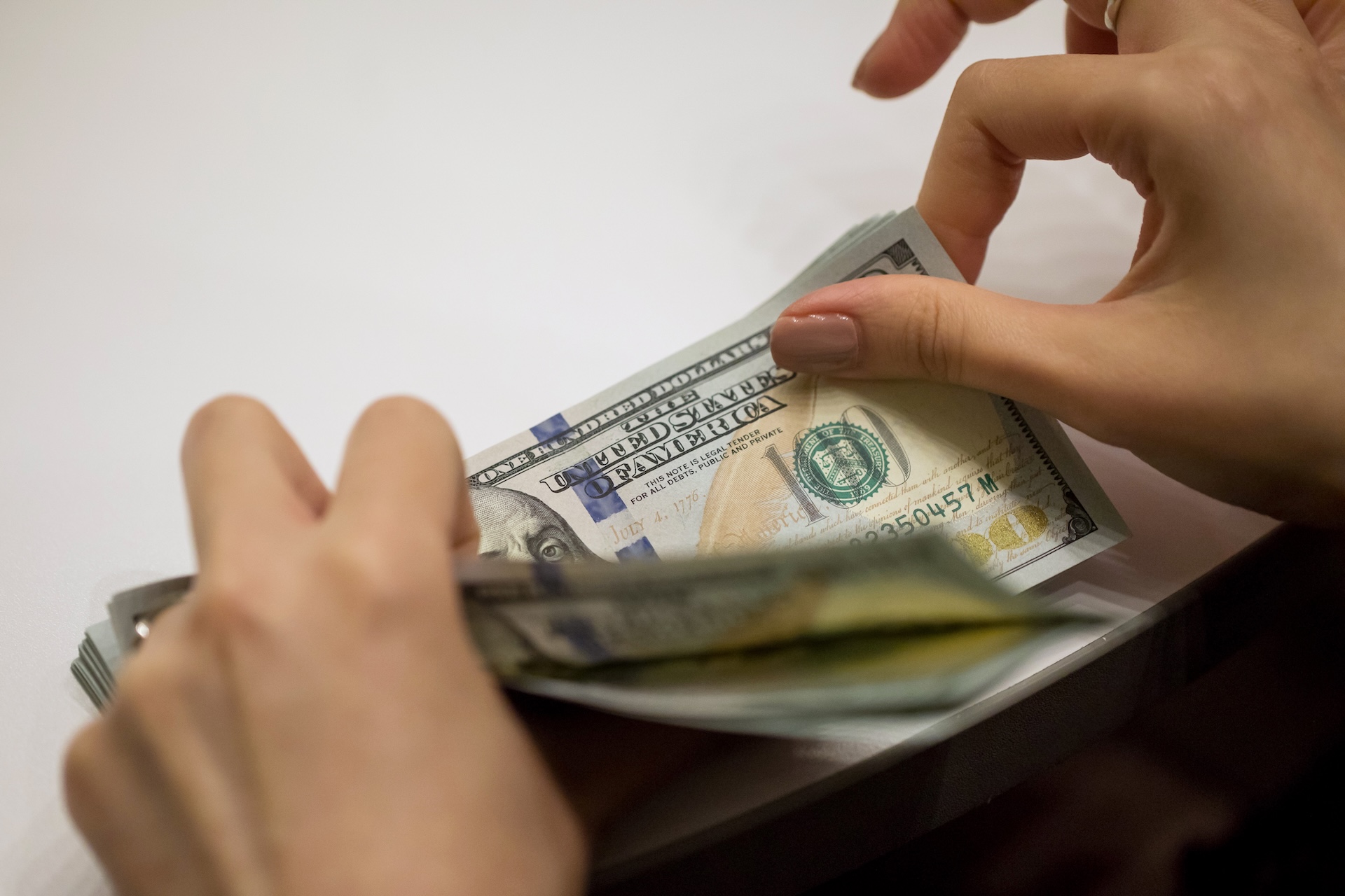 An employee counts U.S. one-hundred dollar banknotes at the Hang Seng Bank Ltd. headquarters in Hong Kong, China, on Tuesday, April 16, 2019.