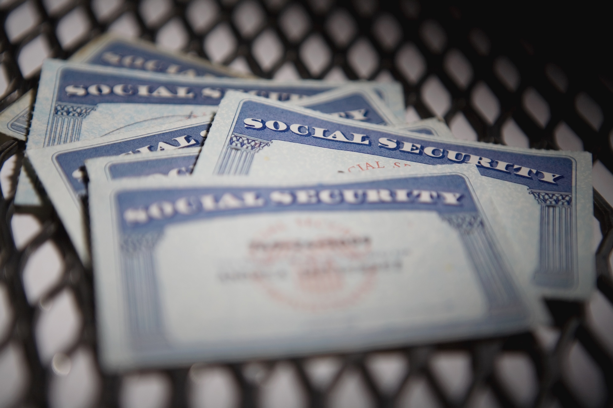 a close up shot of several Social Security cards on a chequered mat.