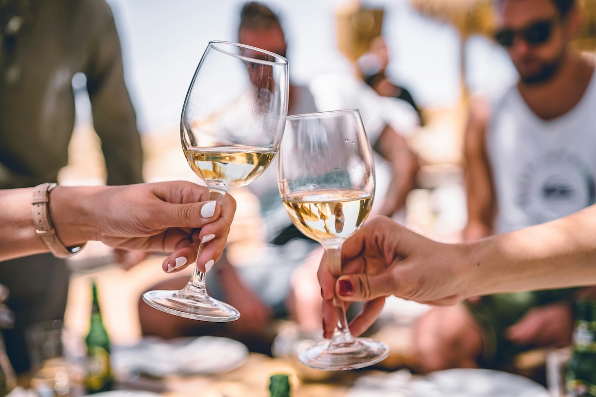 Two women's hands holding wine glasses