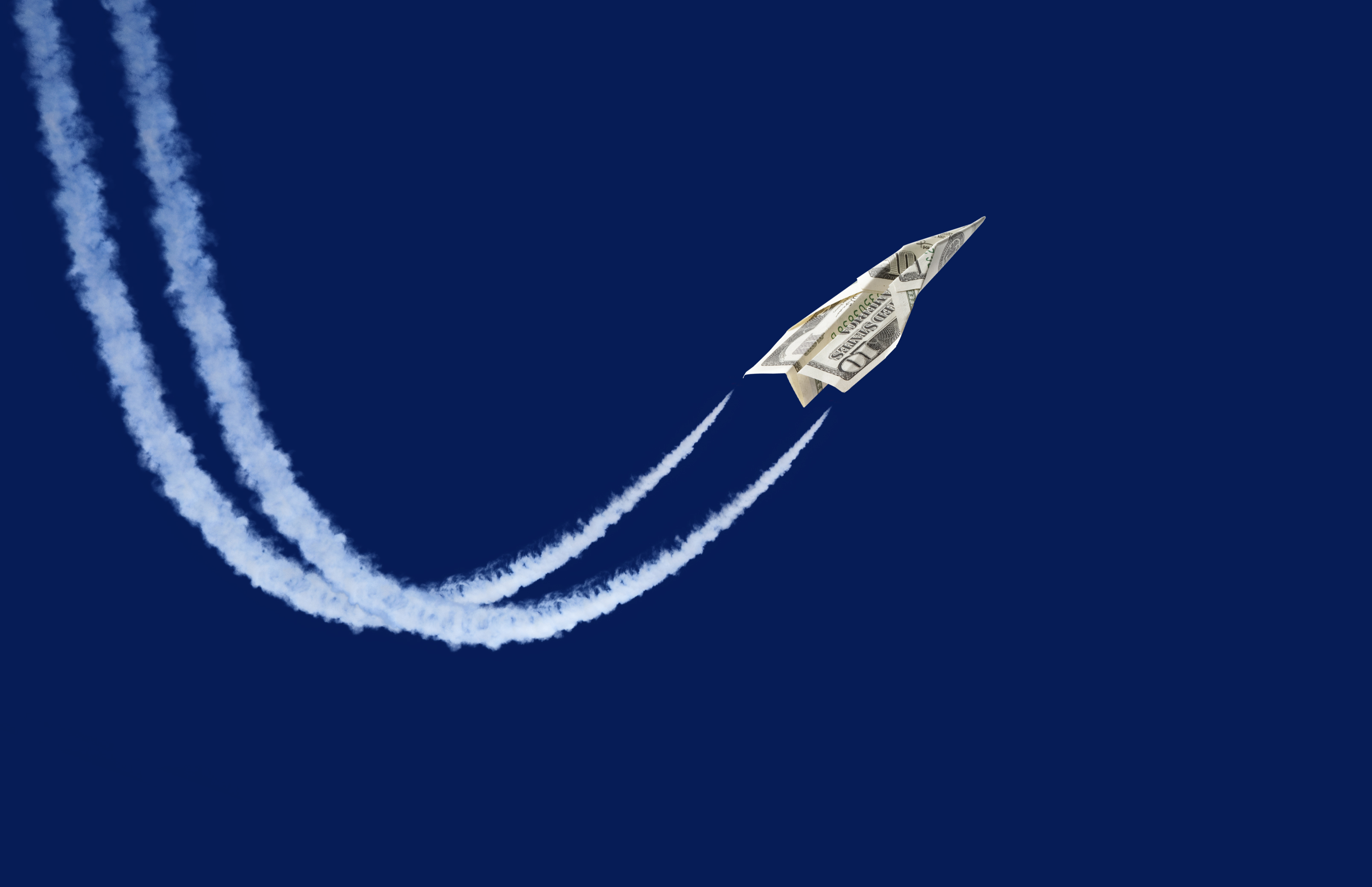 paper plane made from a ten-dollar bill 'flying' with contrails