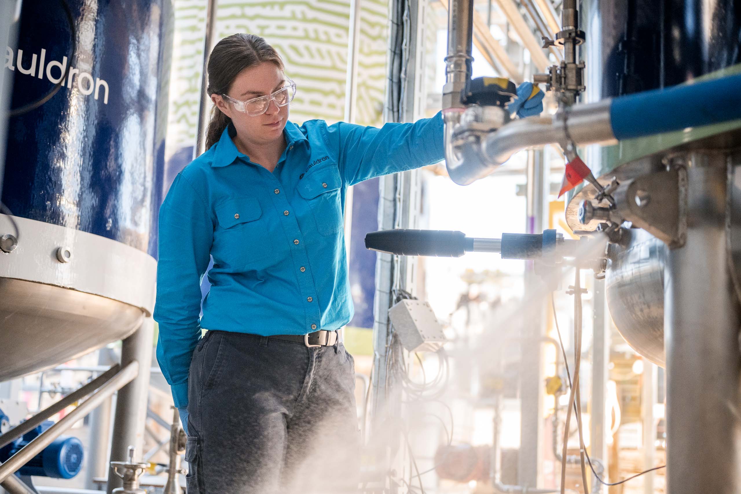 A woman operates a fermenter.