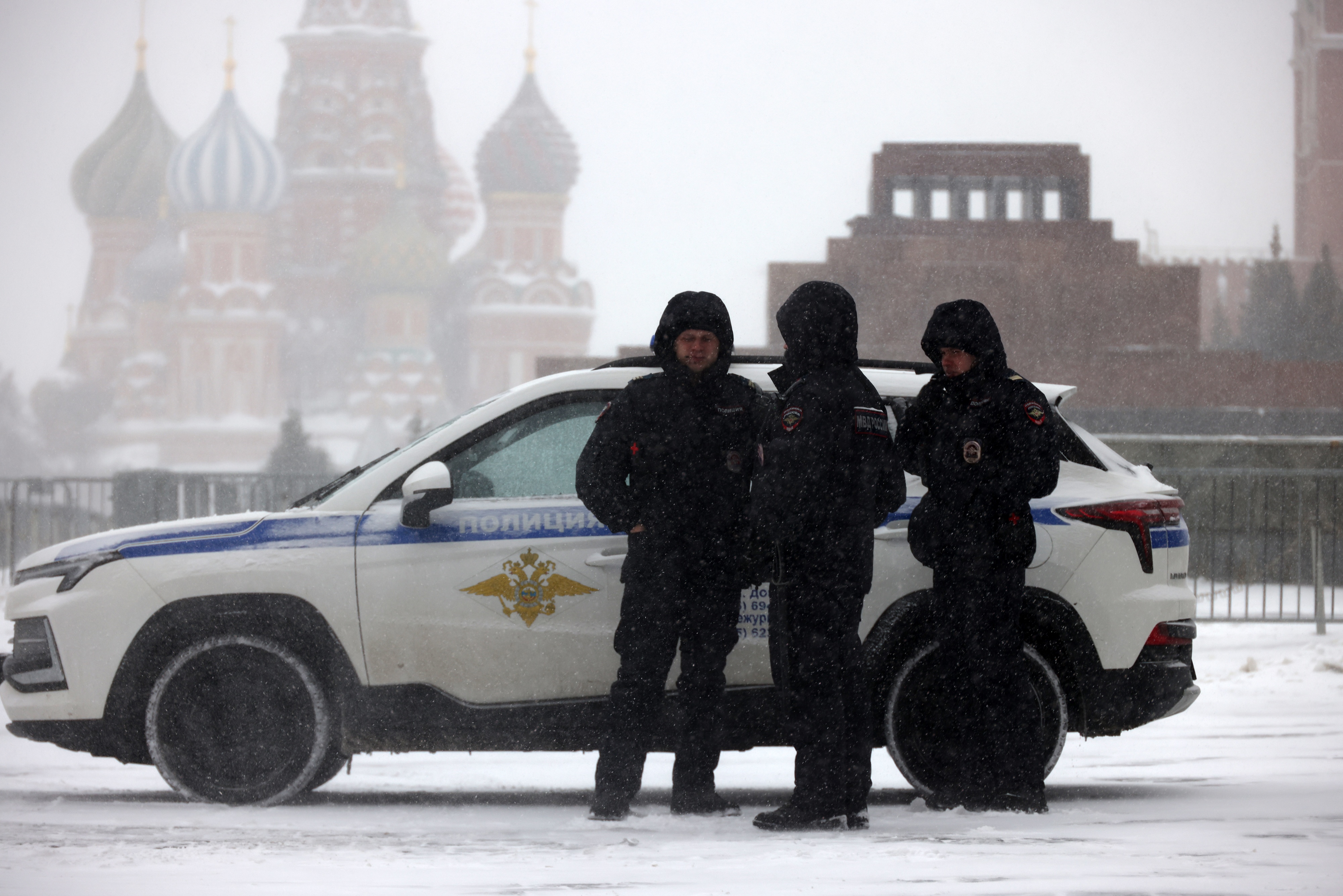Russian Police officers walk during a snowstorm at Red Square, on February 16, 2026, in Moscow, Russia.