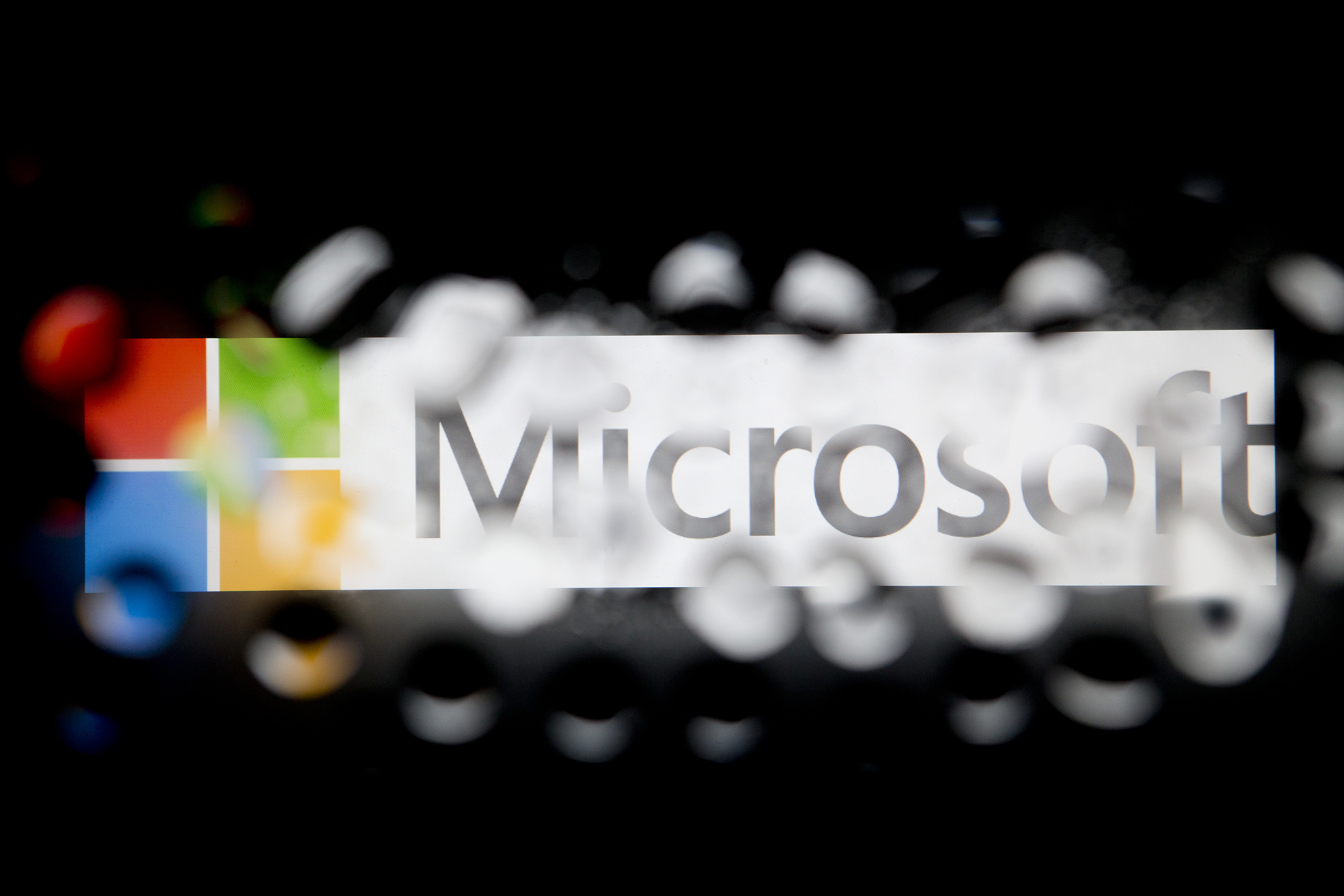 The Microsoft Corp. logo is seen through water droplets.