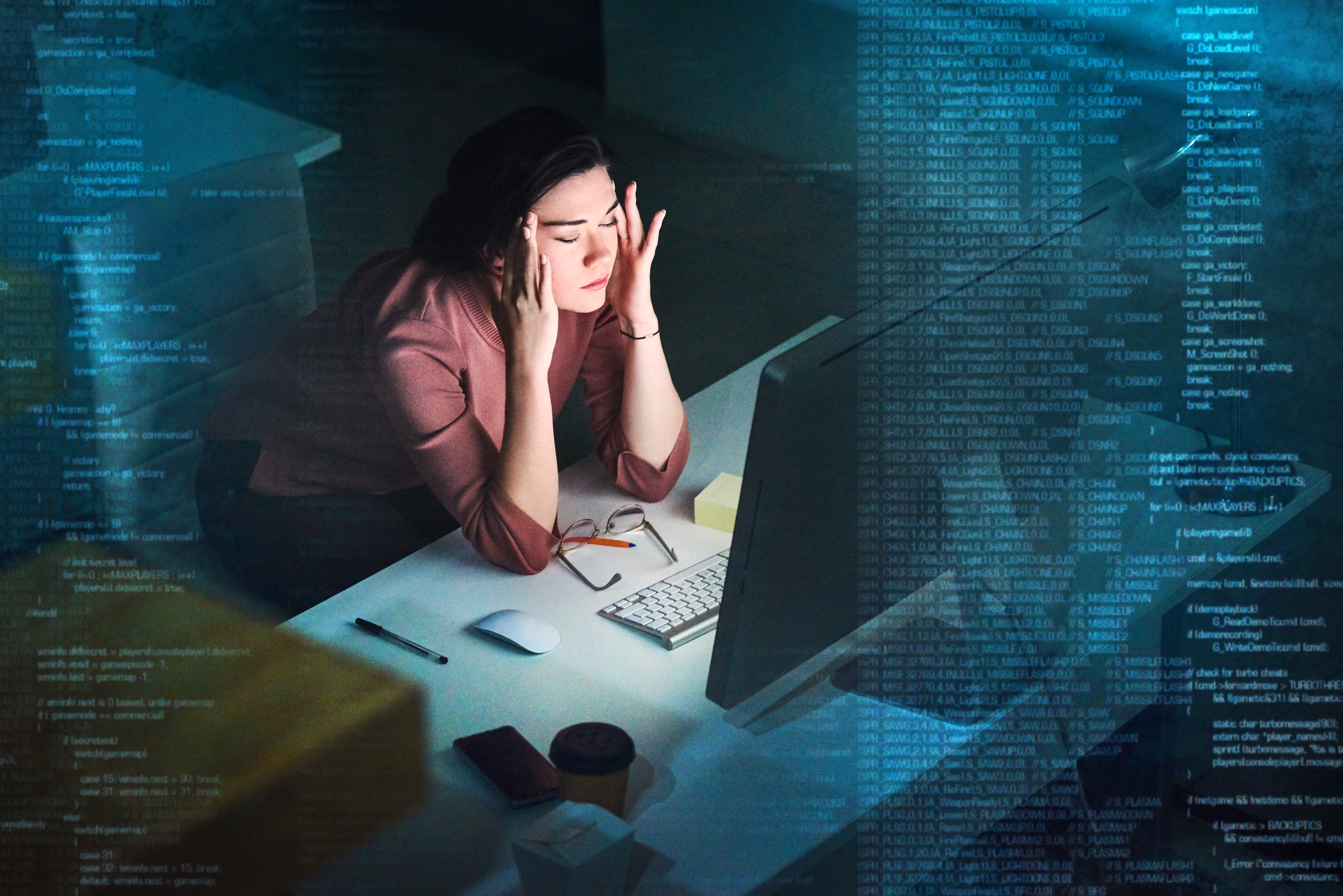 Shot of a young programmer working on computer code at night and looking stressed