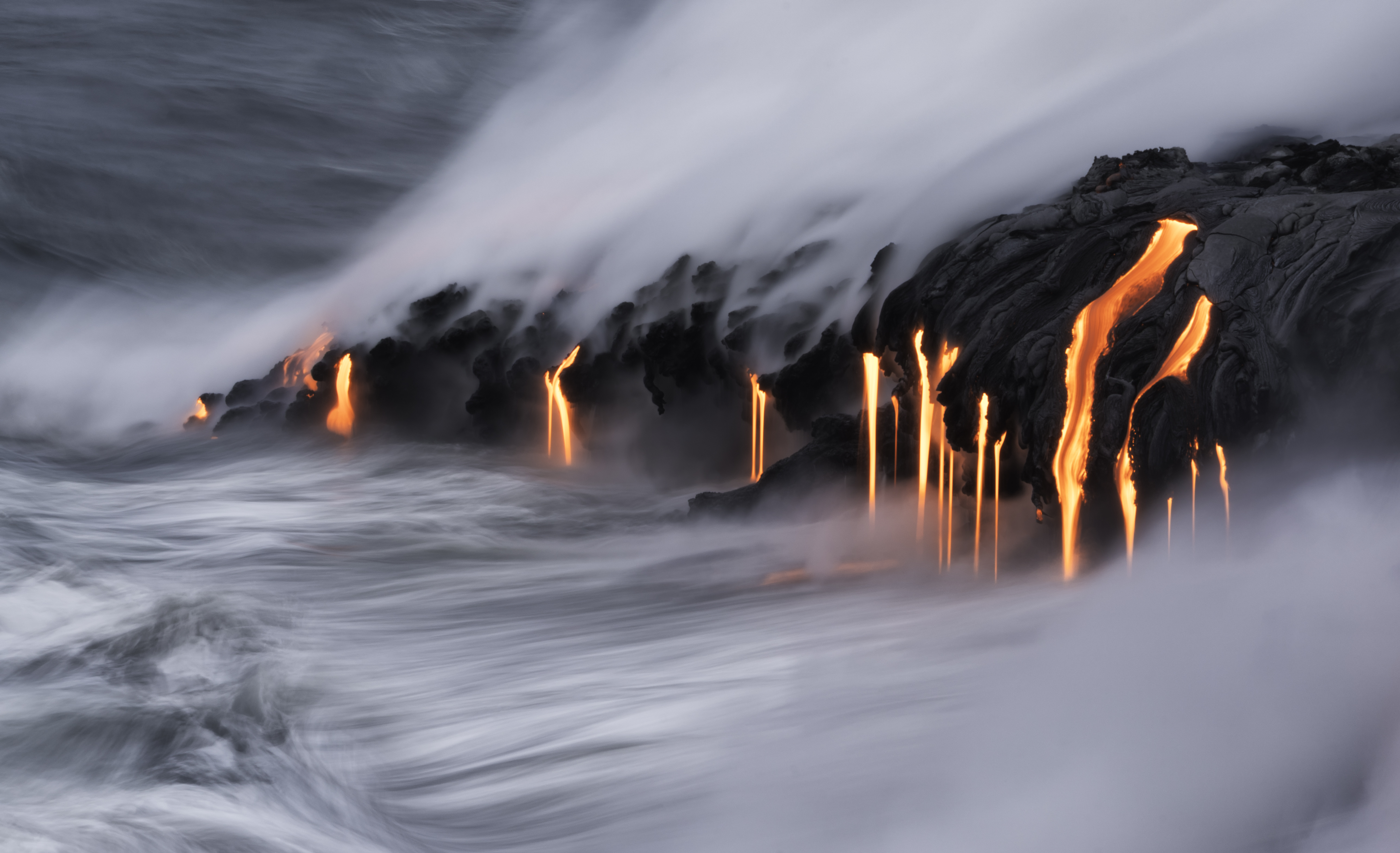Lava pours into the ocean.