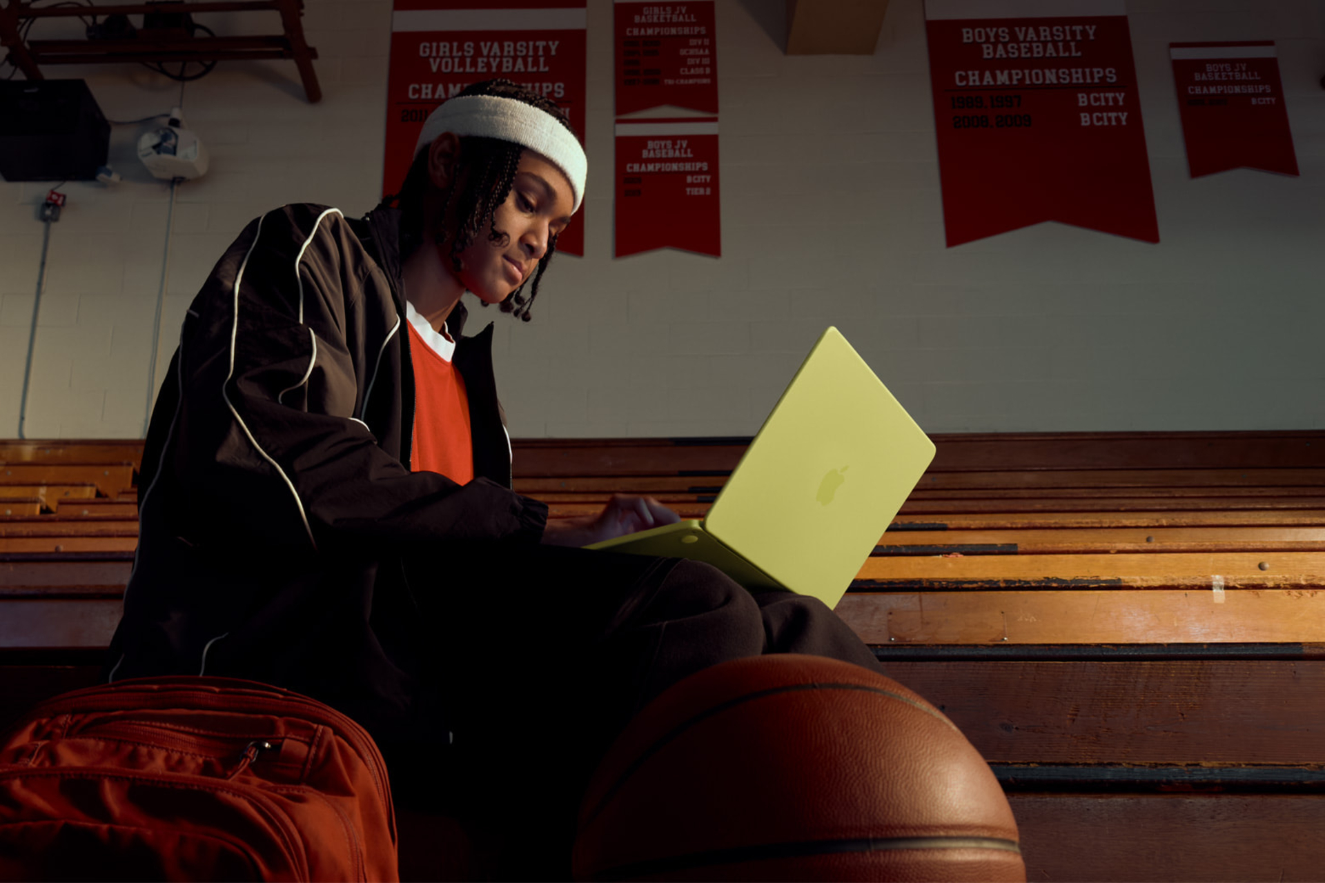 student sitting in a gym working on an Apple MacBook Neo