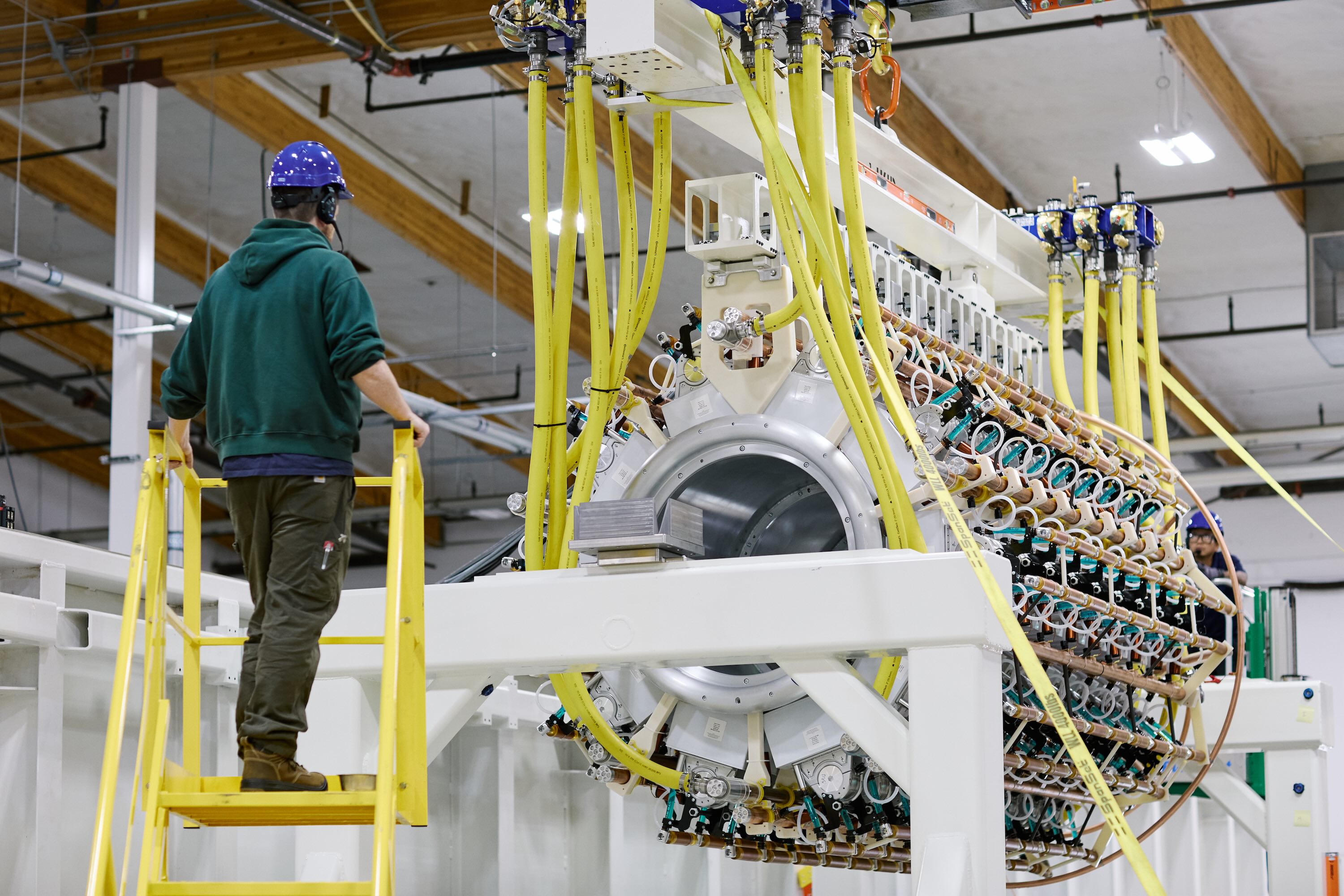 A Pacific Fusion employee inspects a pulser prototype.