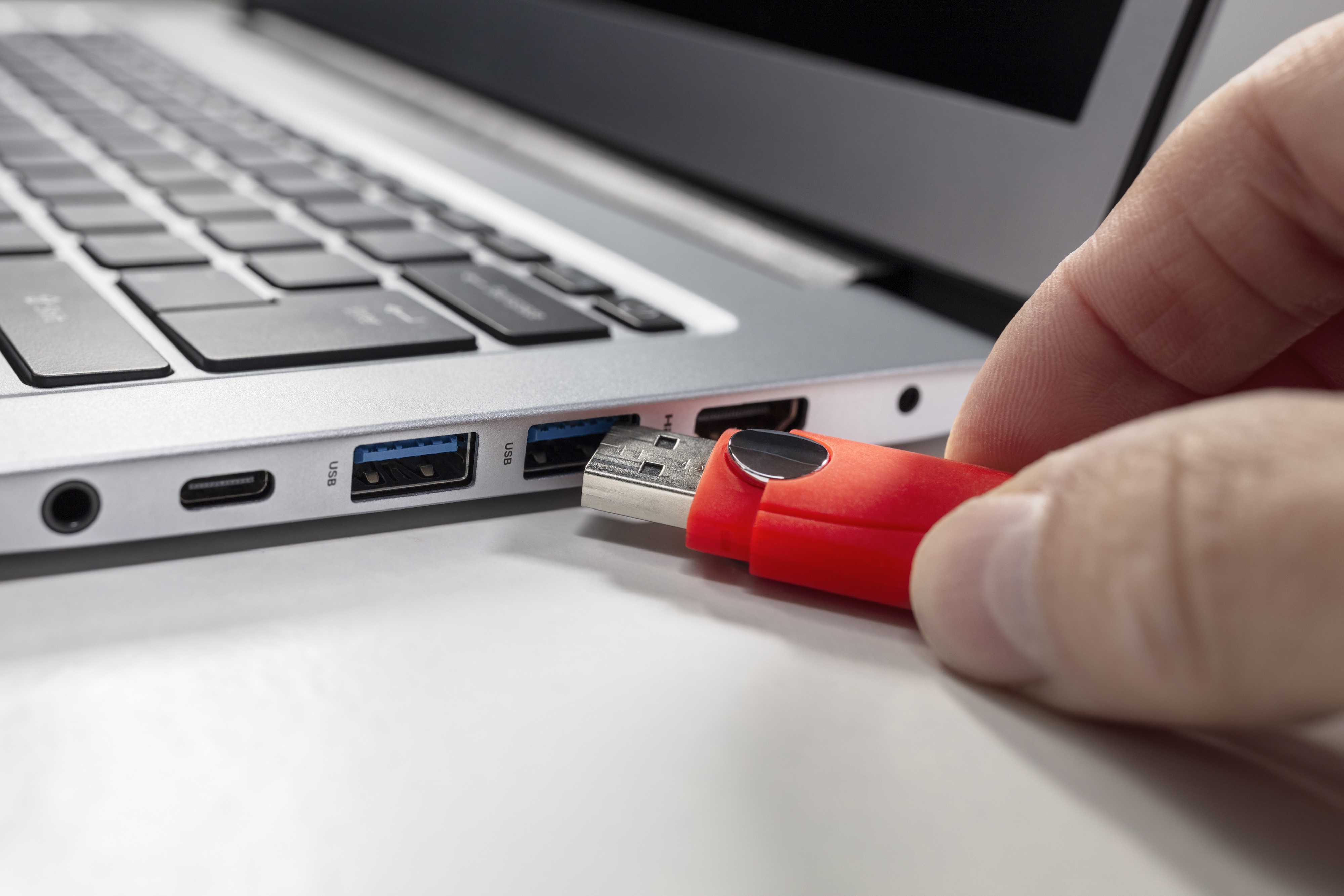 A USB flash drive stick and a laptop computer.
